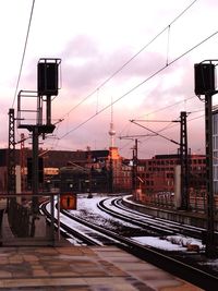 Railroad station against sky during sunset