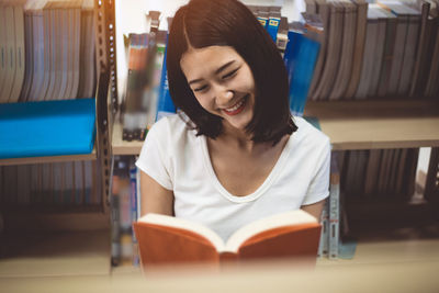 Young woman sitting on book