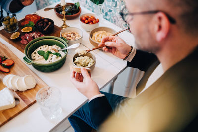 High angle view of man having food at table during dinner party