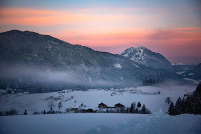 Scenic view of snow covered mountains against sky during sunset