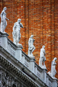 Statue of buddha against brick wall