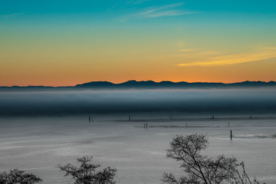 Scenic view of lake against sky during sunset