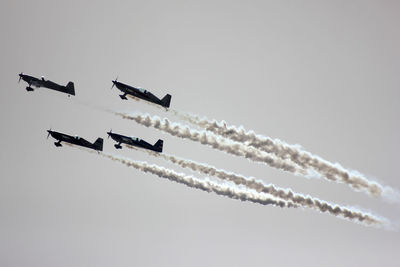 Low angle view of fighter planes performing against clear sky