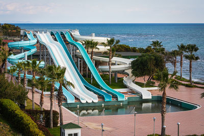 A disabled aquapark with high slides by the sea with a large untreated pool without people 