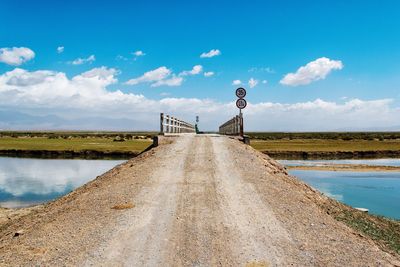 Empty road against cloudy sky