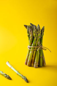 Close-up of bananas on table against yellow background