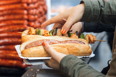 Woman holds fast food meal at street food market