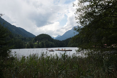 Scenic view of lake by mountains against sky