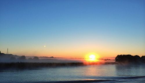 Scenic view of sea against clear sky during sunset