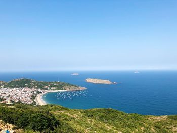 Scenic view of bay against clear blue sky