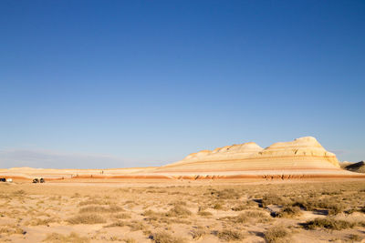 Scenic view of desert against clear blue sky