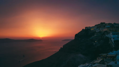 Scenic view of sea and buildings against sky during sunset