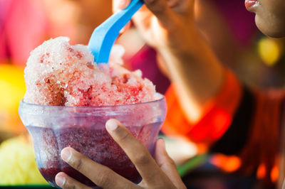 Cropped image of person eating shaved ice