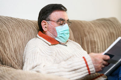 Man using mobile phone on sofa