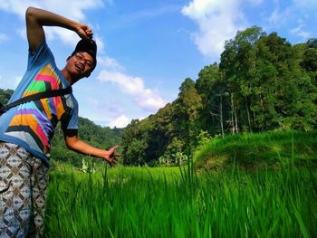 Portrait of man gesturing while standing at rice paddy