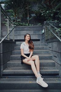 Beautiful smiling woman sitting on staircase outdoors