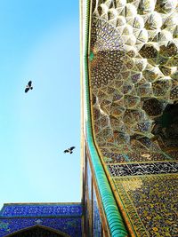 Low angle view of birds flying in sky