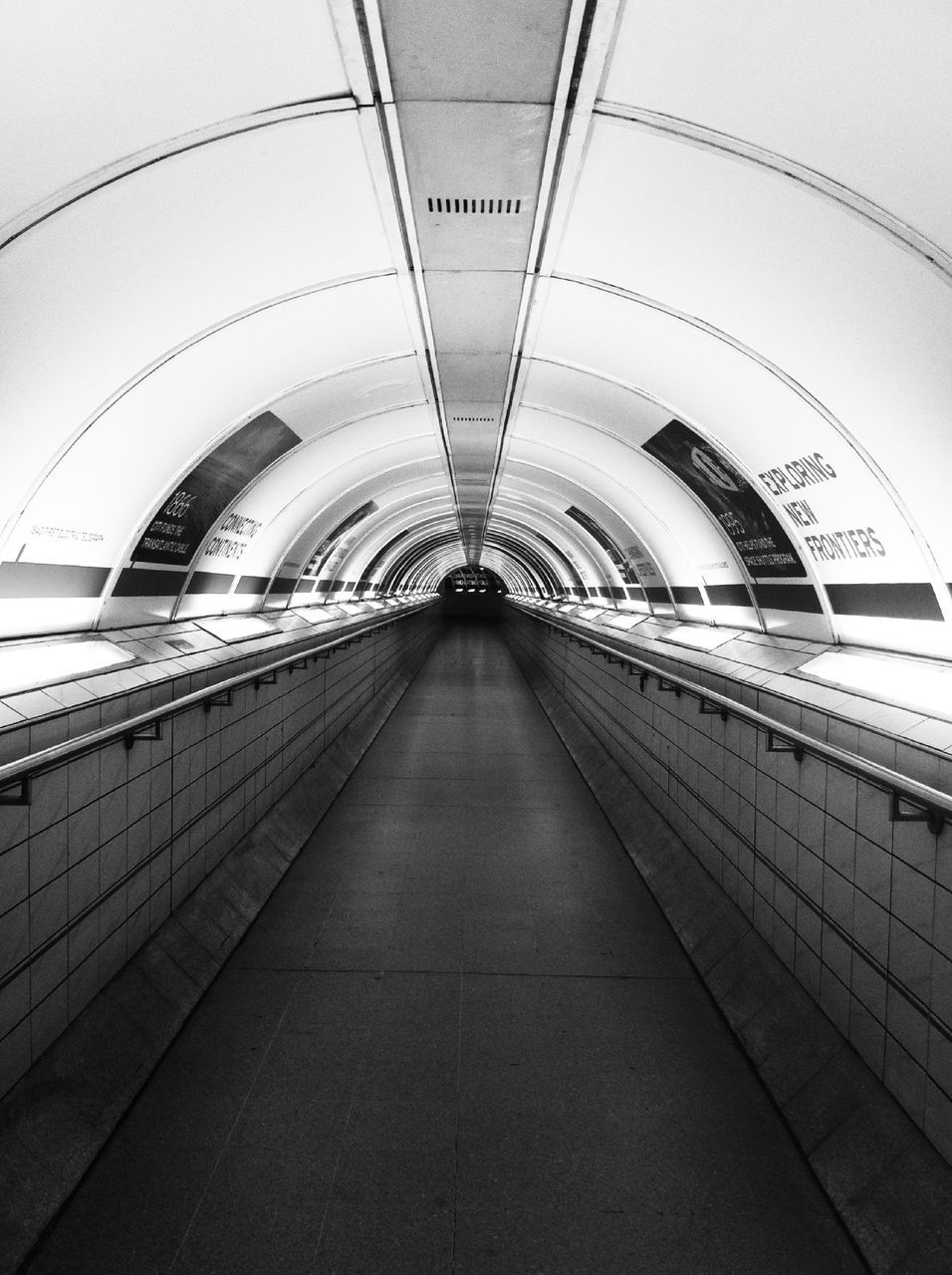 indoors, architecture, built structure, ceiling, the way forward, diminishing perspective, transportation, arch, vanishing point, railroad station, rail transportation, public transportation, interior, modern, empty, incidental people, railroad track, travel, railroad station platform, subway