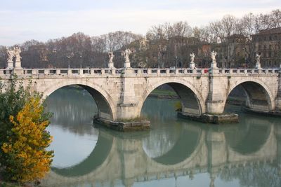 Arch bridge over river against sky