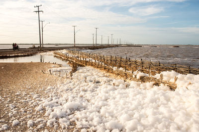 Snow covered shore against sky