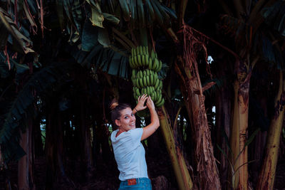 Full length of boy standing against trees