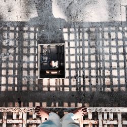 Low section of woman standing by window in city