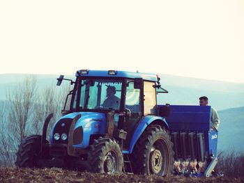 Rear view of man on agricultural field against clear sky