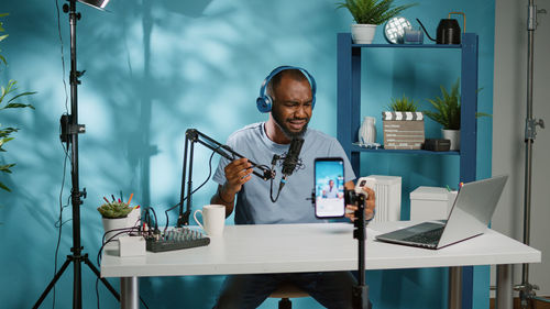 Man using phone while sitting by table