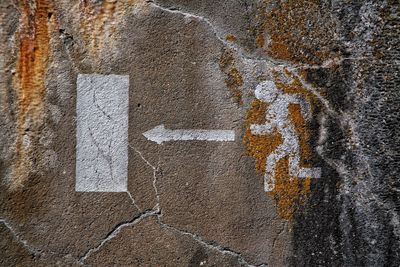 Pedestrian crossing sign on old wall