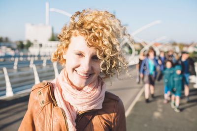 Portrait of smiling young woman standing against sky