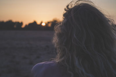 Rear view of man at beach during sunset