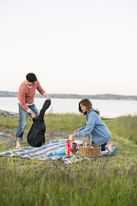 Couple preparing of picnic in field