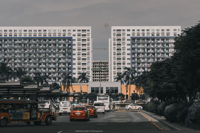 Cars on road by buildings in city