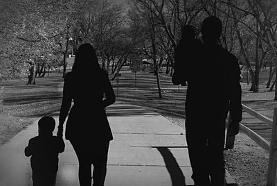 Silhouette of woman standing against bare tree