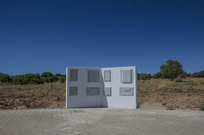 Built structure on field against clear blue sky