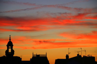 Silhouette buildings against sky during sunset