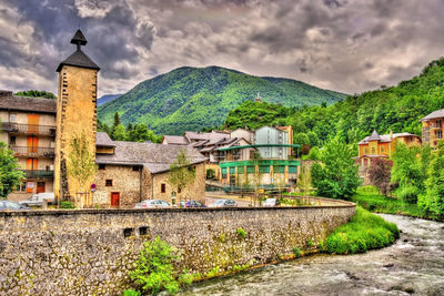 Buildings by mountains against sky