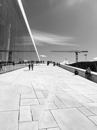 People walking at oslo opera house against sky