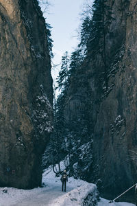 Woman on snow covered mountain against sky