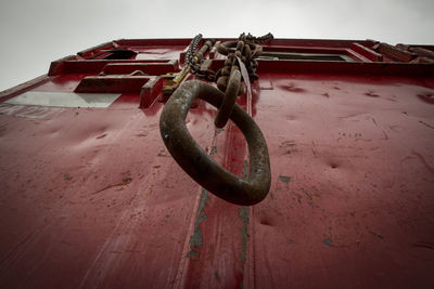 Close-up of rope tied on rusty metal against sky