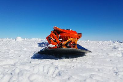 Close-up of snowboard on snow against clear sky