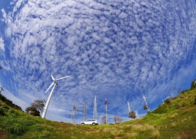 Wind turbines on mountain against sky