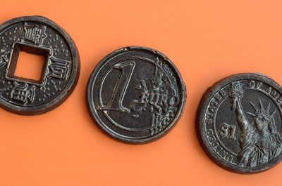 Close-up of coins on orange background