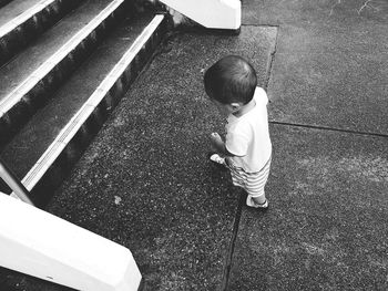 High angle view of baby boy walking towards steps