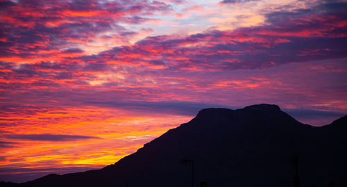 Low angle view of silhouette mountains against romantic sky