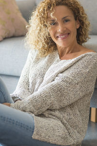 Portrait of young woman sitting on bed at home