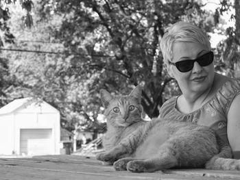Close-up of mature woman standing by cat at park
