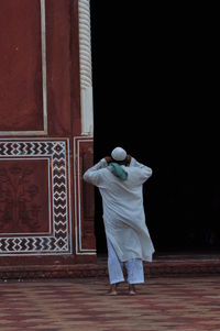 Rear view of man standing against wall