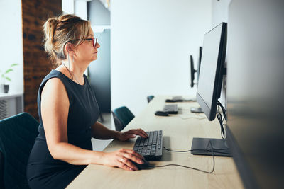 Concerned businesswoman working on computer in office. busy woman sitting at desk at front of pc