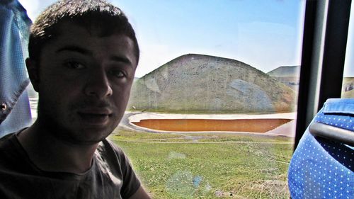 Portrait of young man looking through window